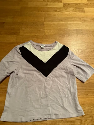 T-shirt - Fin ljuslila T-shirt med vita och svarta detaljer