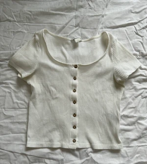 VIT RIBBAD BLUS - En fin, knappast använd vit ribbad blus med knappar på framsidan! 
