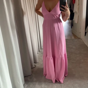 Rosa långklänning 🩷 - Rosa långklänning från Gina Tricot 🩷Storlek S och passar mig bra som är XS och 170 cm lång! I fint skick, har precis lagat ett av bandet då det varit av! 