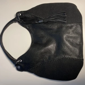 Väska - Stor svart väska med tofs. Väskan är ca 30 cm jup och 40 cm bred.  Skriv om mer info/bilder behövs!😋
