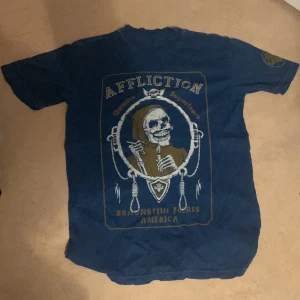 Affliction t-shirt - Sitter som en L och kan passera som en M. Lite dålig cond skulle säga 5,5/10 därav priset. Det finns små hål runt om tröjan