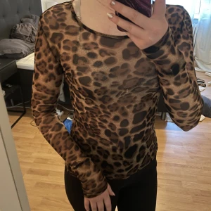 Topp i mesh - Leopardmönstrad topp i Mesh, genomskinlig. Använd men i fint skick.  Storlek XS-S, stretchig i tyget. 
