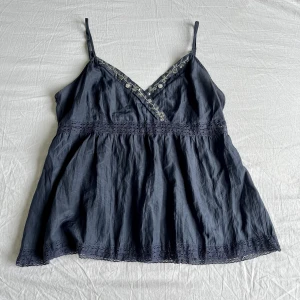 Blå topp <3 - Säljer min superfina volangtopp då den tyvärr är för liten för mig🫶 Den har detaljer av blommor och pärlor i silver, & såklart är den hel och ren 💞 Använd köp nu och skriv om du har några funderingar 🩷