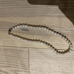 Pärlhalsband  - Sötvattenspärlhalsband från NA-KD säljes! Superenkelt att ta av och sätta på då den öppnas och stängs av magneter.