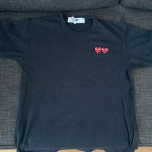 COMME des GARCONS T-shirt - Hej! Jag säljer min cdg play t shirt eftersom jag har vuxit ur den. Köpt på NK för 1200 kr. Strl är M men jag skulle säga att den passar XS-S. Tröjan är välanvänd men ändå bra skick 7/10. Tröjan passar till både tjej och kille!