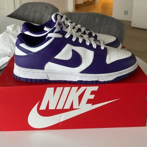 Nike dunk low court Purple  - Säljer nu mina Nike dunk court Purple då dom helt enkelt inte kommer till användning. Skorna är i storlek 42 och har använts 10-20 gånger men är i mycket bra skick. Skorna är köpta på JD sports. Kartong finns. Skriv om ni har frågor. 