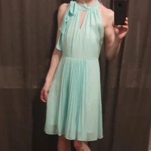 Traffic People mintgrön klänning med knytkrage och plissering i chiffong - Kortklänning med knytning i halsen. Plisserad framtill. Söt samtidigt som elegant! :)   Luftig och perfekt att klä upp sig i nu under sommarkvällarna (och dagarna) 🤗  Använd bara 2 gånger (max). Således nyskick. Köpte inför en väns 30-årsfirande :) 