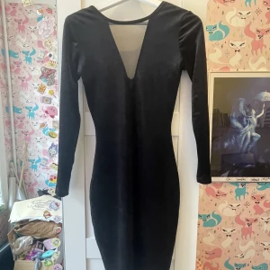 Svart festklänning  - Krossat sammet, går ner till knäna, jag är 171 lång. Svart med genomskinlig mesh fram i V beskärning och öppen rygg. Stretchigt tyg