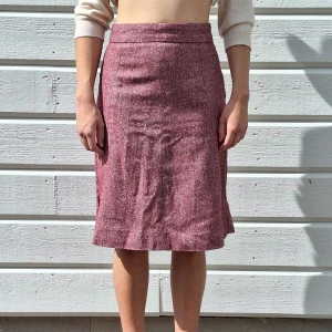 Kjol - Ljusare vinröd kjol. Med inslag av olika färger i tyget. Se den närmare bilden på tyget.