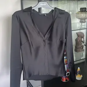 Säljer denna svarta satinskjortan då den inte kommer till användning, skjortan har en knapp vid bröstet ungefär. Så snygg topp om man ska på middag eller fest🖤