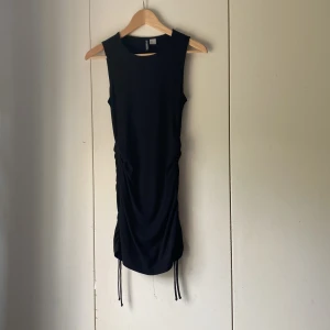 Svart klänning - Jag säljer nu den här svarta korta klänningen. Den slutar mitten på mina lår på mig och men kan dras åt på sidorna så att den blir kortare eller längre.💗