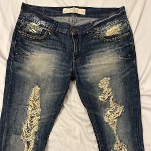 Vintage lågmidjade jeans med nittar i toppenskick. Strl 26. Märke Abercrombie & Fitch (New York). Jeansen är raka i modellen. 