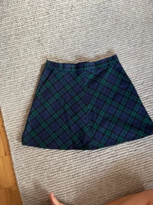 Tartanmönstrad kjol - Kjol i blå/svart/grönt tartanmönster från ”beyond retro label”. Perfekt skick