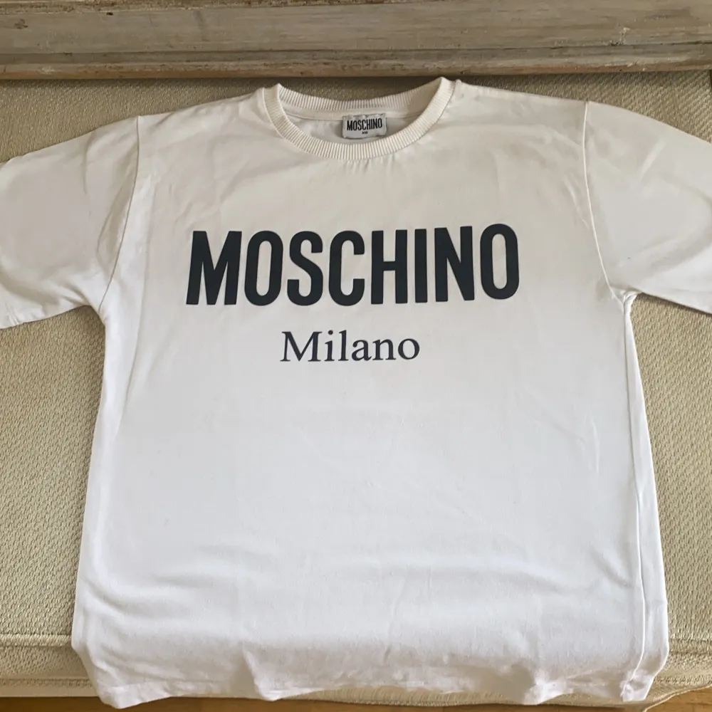 Moschino tshirt junior i perfekt skick. Finns i Bandhagen.  Kan skickas, köparen står för frakten . T-shirts.