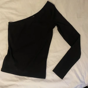 Långärmad one shoulder - Säljer min svarta långärmade topp som är one shoulder! Jättesnygg som den är eller stylear upp med en kavaj💕