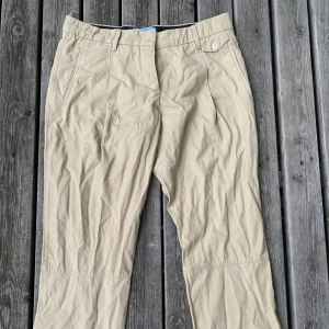 Prada Chinos - Prada chinos i snygg beige färg, passar bra till allt!! Storlek 42 i 100% bomull. Lite kortare i modellen så passar bra till sommaren och en gullig sko <3