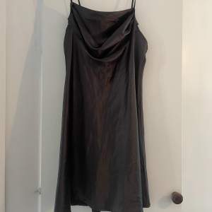 Säljer denna svarta silkesklänning i storlek XL men den är liten i storleken. Aldrig använd.
