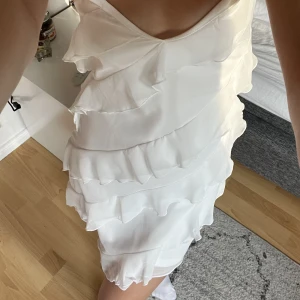 Vit klänning Nelly - Säljer denna fina klänning med volanger från Nelly i strl 34. Använd en gång🩷🩷