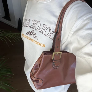 Väska - Super snygg brun väska, har såå många fack! Vintage väska som aldrig används, finns bilder på hur väskan ser ut innuti i (inga fläckar eller märken). Perfekt färg nu i höst