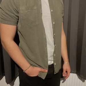 Kort ärmad skjorta - Kort ärmad skjorta från Lagency, jätte fin färg passar bra till alla underdelar. Går att bara ha skjortan som den är, men även jätte fint med tshirt under! Pris kan diskuteras