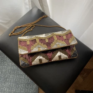 Axelremsväska - Axelremsväska med paljetter från Beck Söndergaard. Fin men kommer inte till användning:( 