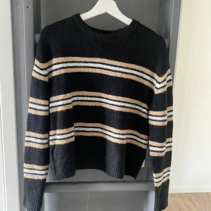 Randig stickad tröja - Mysig svart stickad tröja med randigt mönster. Tröjan är från HM och bara använd någon enstaka gång. Storlek S.