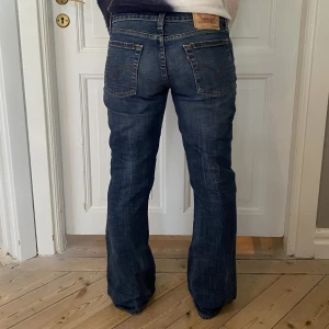 Lågmidjade Levis jeans - De perfekta lågmidjade Levisjeansen i mörk tvätt och utsvängda ben. Superfint skick💕 Storlek S-L beroende på hur man vill att de ska sitta👖 Skriv vid funderingar och kolla in alla andra snygga plagg jag säljer😇💗