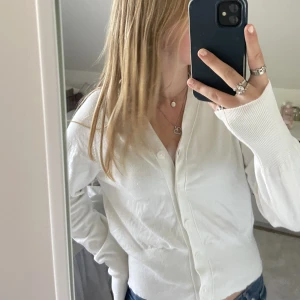 Kofta  - En mjuk fin vit kofta med knappar, aldrig använd 