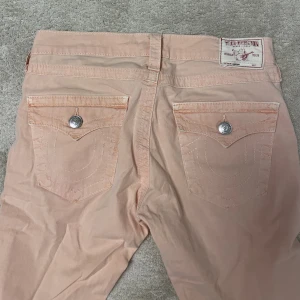 ROSA TRUE RELIGION JEANS - Rosa skinny true religion jeans, lowwaisted och lite tunna i materialet, inte riktigt som vanliga jeans. As coola men måste sälja då dom inte passade i midjan. Köpta på sellpy och inga defekter. Snygga att klippa till tex shorts