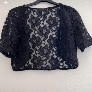 Bolero  - Säljer denna marinblåa boleron som är i blommigt mönster. 