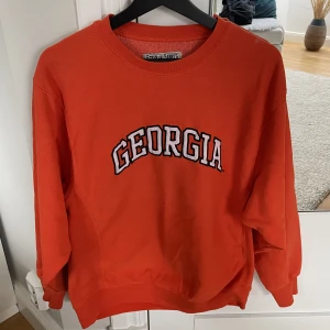 Collegetröja - Orange collegetröja med texten ”Georgia”