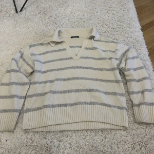 Randig stickad tröja - Randig stickad tröja i beige/grå från Ginatricot. Använd få gånger! Sitter fint oversized på mig som har S i vanliga fall! 🩷