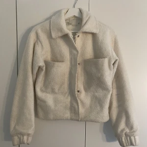 Teddy jacka - Vit teddyjacka i kortare modell. Från Nelly. Båda ärmarna ser likadana ut, tror det borde gå bort i tvätten.