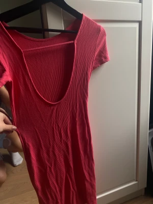 Klänning  - Rosa tajt klänning med öppen rygg. Är i ribbat material och skapar en fin pass from