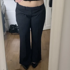 Lowwaist Bootcut kostymbyxor - Ett par blå svart randiga kostymbyxor med bootcut, har sytt upp dom själv i benen och är 163 och har storlek L i byxor💕