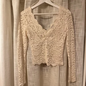 Spetstopp zara - Vit/off-white, långärmad topp från Zara. Toppen är genomskinlig i spets samt v-ringad både fram och bak. Använd men fortfarande i fint skick!❤️Storlek S men passar även mig som normalt sätt bär XS (den har lite stretch)  Använd gärna köp nu-funktionen❤️