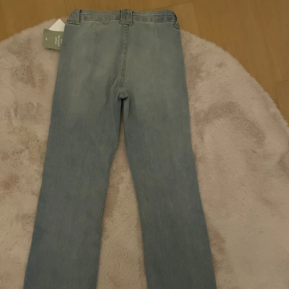 Nyköpta bootcut jeans från H&M och de är inte använda någon gång därav sitter prislappen kvar. Jättesnygg blå tvätt och påminner om 90s. Kvitto finns. Det är storlek 34 men passar även 32 och 36 då de är såpass stretchiga.. Jeans & Byxor.