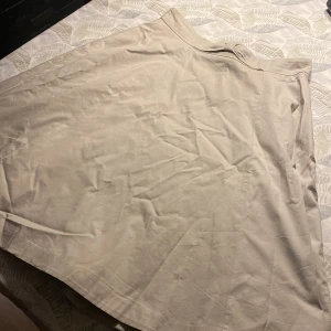 Kjol - Ljus beige/vit kjol från h&m, går en bit ner över knät Två små fläckar men annars hel
