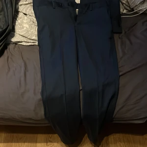 Mörk blå Kostym  - Allting är från These Glory Days. Vill helst sälja hela kostymen med kavaj,byxor och skjortan för ett schyst pris. (Den är Slim fit)  Skjortan Strl S tror jag. Kavajen Strl 46 och Byxorna Strl 44.  Skriv om frågar och går diskutera priset eller byte.