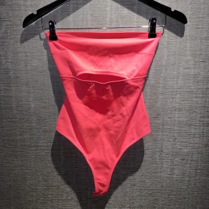 Body | Bershka - En neonrosa strapless body i storlek XS från Bershka. Jag skulle dock säga att den även passar S. Aldrig använd. Skriv privat för mer bilder och info.