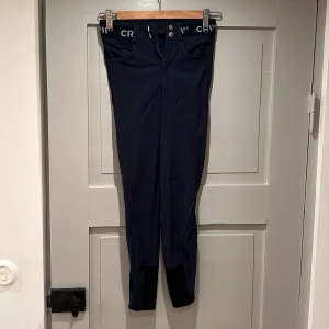 Marinblå ridbyxor  - Tunna och något stretchbara ridbyxor (ej tights) med ”gummiprickar” på rumpa och insida ben för bra fäste. Storlek 160 men verkar snarare vara 152. 