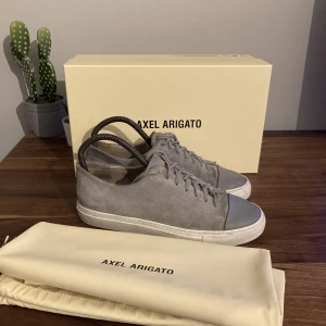 Axel arigato cap toe (grå) - Riktigt snygga arigato skor med toe box/cap Dm för andra svar och frågor! Allt OG med följer!sulan är lite smutsig men de går att fixa