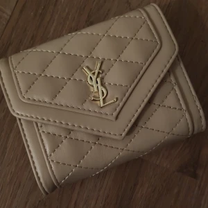 Ysl plånbok - Säljer en ny ysl ( ej äkta) plånbok i beige färg 