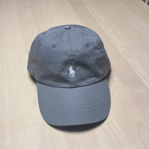  Ralph Lauren Keps  - Knappt använd Polo Ralph Lauren keps i fin grå färg. 