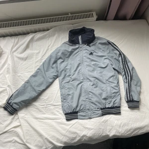 Adidas windbreaker - Adidas windbreaker i storlek M, perfekt nu till hösten. Är perfekt att ha från vår till höst. Väldigt bra skick, inga defekter. Ingen luva. Dm för mer bilder och mått. Läs bio