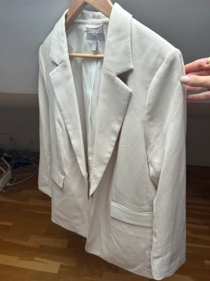 Kavaj - Säljer min kavaj/blazer från hm, den är ljusbeige och helt ny! Aldrig använd.  Storlek L