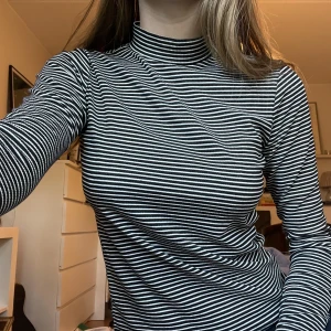 Randig tröja - Randig tröja med en liten polokrage i ribbat tyg.