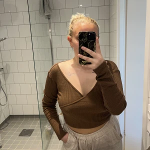 Omlotttröja - Superfin brun v-ringad långärmad tröja. Knappt använd i toppenskick. Tröjan är INTE genomskinlig alls och gjort av supermjukt material. Väldigt stretchig. 