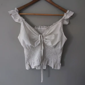 Vit topp med volanger - Supergullig topp som tyvärr aldrig kommer till användning. Osäker på märke då lappen saknas. Det står storlek L men den passar mig som brukar ha S bra, dock är den väldigt stretchig så kan även passa M.