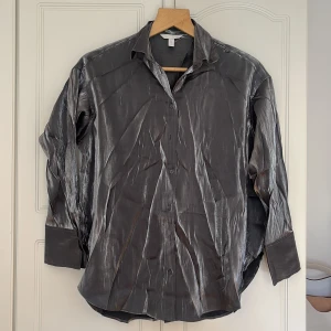Skjorta h&m - Snygg skjorta i silver från h&m. Oanvänd